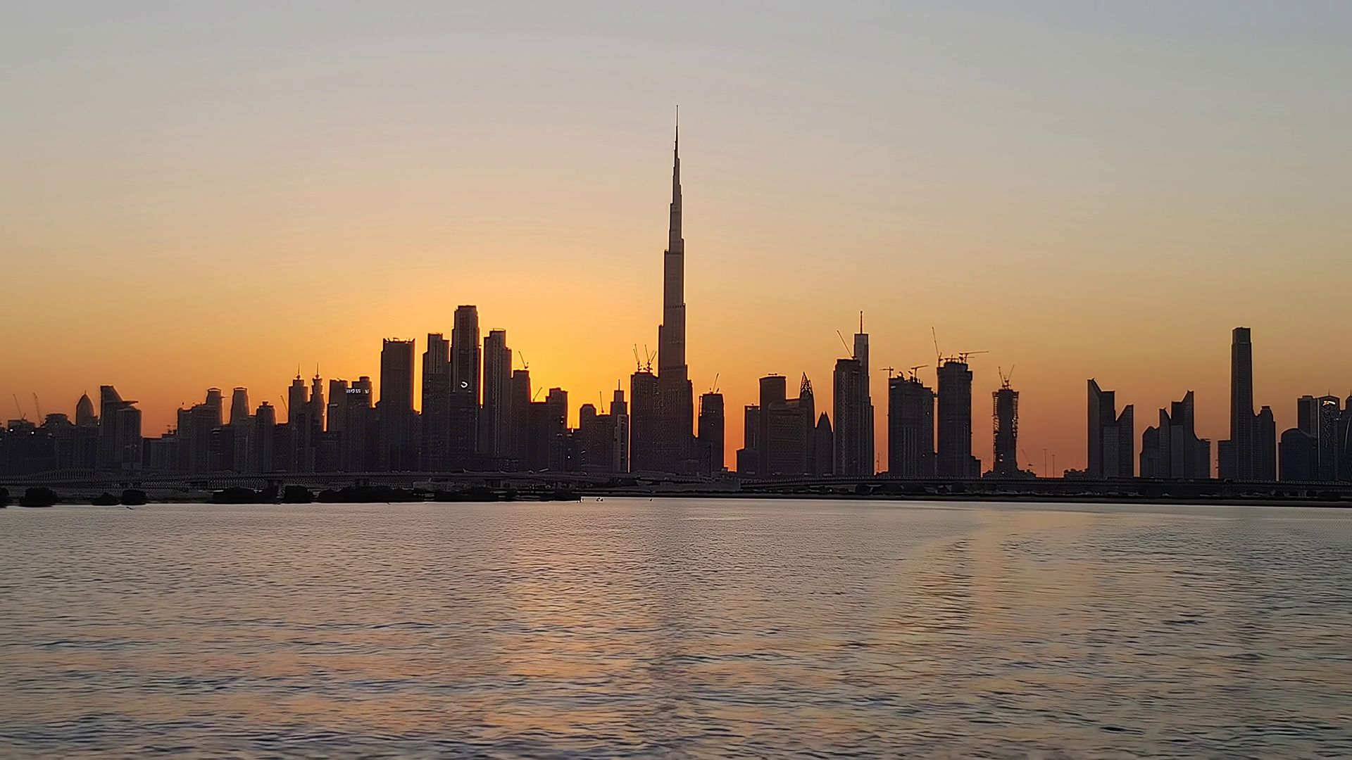 The Dubai skyline at sunset across the water